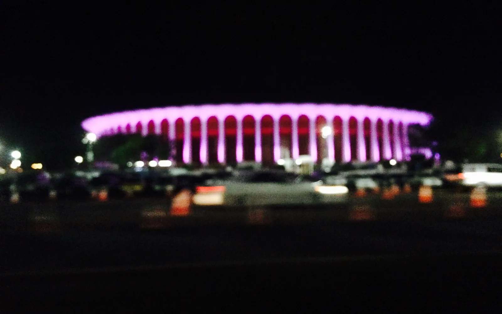 Nighttime exterior view of The Kia Forum (formerly The Forum) in Inglewood, showing the distinctive circular structure and marquee lighting